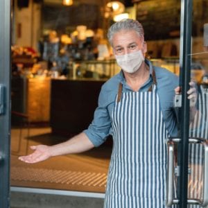 business-owner-wearing-a-facemask-and-reopening-his-cafe-after-the-picture-