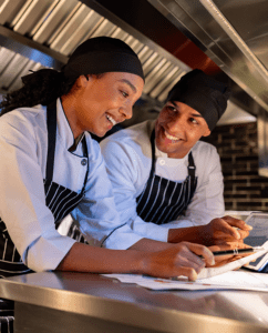 Two foodservice workers talking at counter. for articleL The Importance of Third-Party Gap Assessment for a Food Safety Management Program